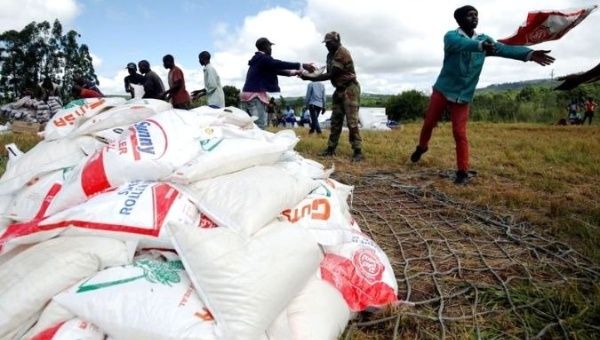 A group of people stack maize donated after Cyclone Idai ravished Zimbabawe. 