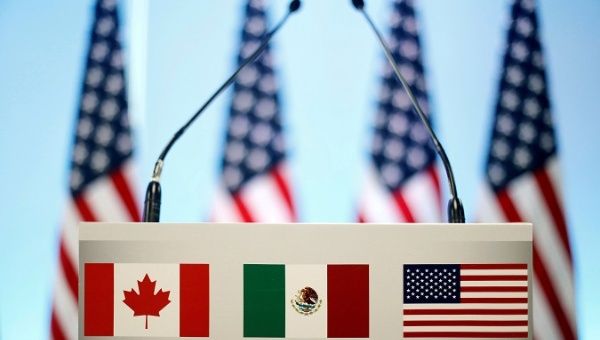 The flags of Canada, Mexico and the U.S. on a lectern before a joint news conference on the closing of the seventh round of NAFTA talks in Mexico City, Mexico March 5, 2018. 