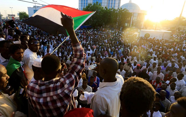 Sudanese demonstrators wave their national flags as they attend a mass anti-government protest outside Defence Ministry in Khartoum, Sudan April 21, 2019.