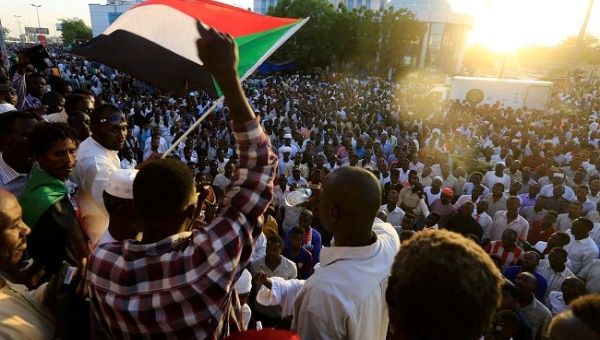 Sudanese demonstrators wave their national flags as they attend a mass anti-government protest outside Defence Ministry in Khartoum, Sudan April 21, 2019.