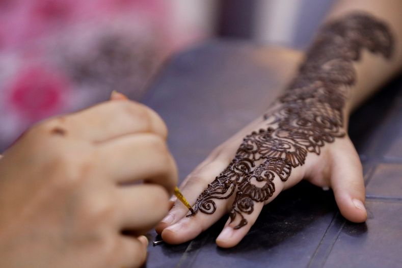 A girl gets her hand decorated with traditional henna patterns to celebrate Eid-al Fitr in Karachi, Pakistan.