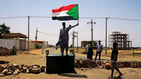 A Sudanese protester holds a national flag, demanding that the country's Transitional Military Council hand over power to civilians, in Khartoum, Sudan June 5, 2019. 