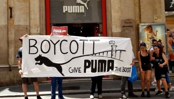 Pro-Palestine activists protest outside a Puma store.