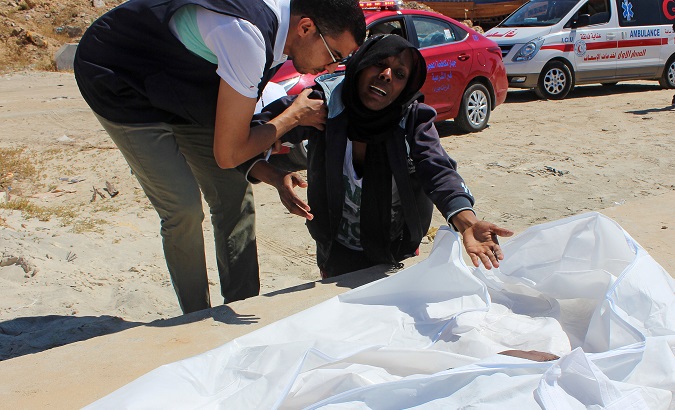 Migrant woman reacts next to the body of her child after a boat accident off the Libyan coast, in Qarabulli town, Libya June 2, 2019.