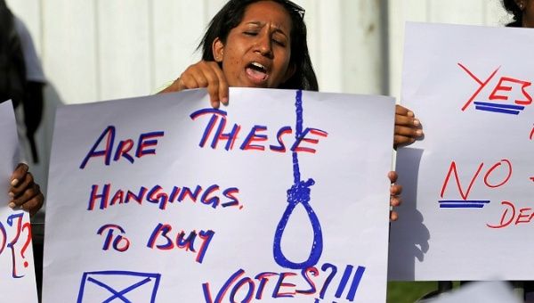 A Sri Lankan woman holds a placard during a protest condemning signed death sentences for four people convicted of drug-related offences.