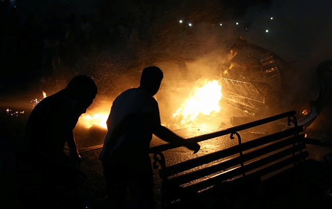 People extinguish a fire from a blast outside the National Cancer Institute, Cairo, Egypt August 4, 2019.