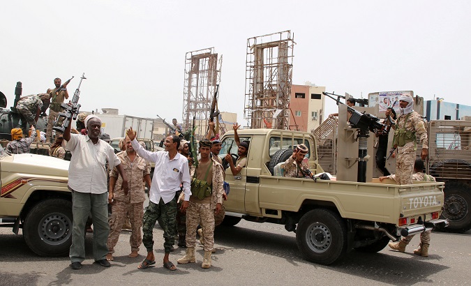 Members of UAE-backed southern Yemeni separatist forces shout slogans as they patrol a road during clashes with government forces in Aden.