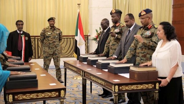 Leader of Sudan's transitional council, Lieutenant General Abdel Fattah Al-Abdelrahman Burhan looks on as military and civilian members of Sudan's new ruling body, the Sovereign Council, are sworn in at the presidential palace in Khartoum, Sudan, August 21, 2019. 