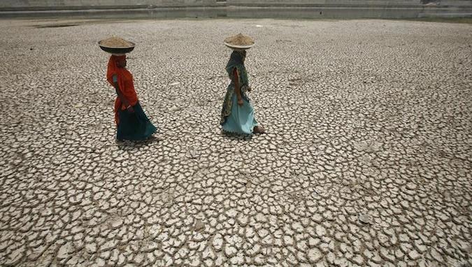 Women labourers carry mud to a construction site on the dried banks of river Sabarmati on a hot day in Ahmedabad May 21, 2011.