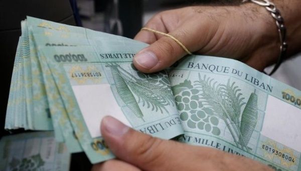 A man counts Lebanese pounds at an exchange office in Beirut, Lebanon, August 16, 2018. 