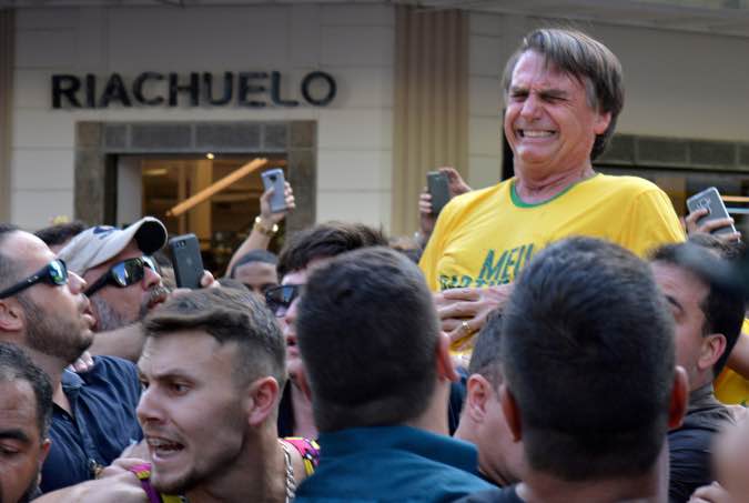 Brazilian presidential candidate Jair Bolsonaro reacts after being stabbed during a rally