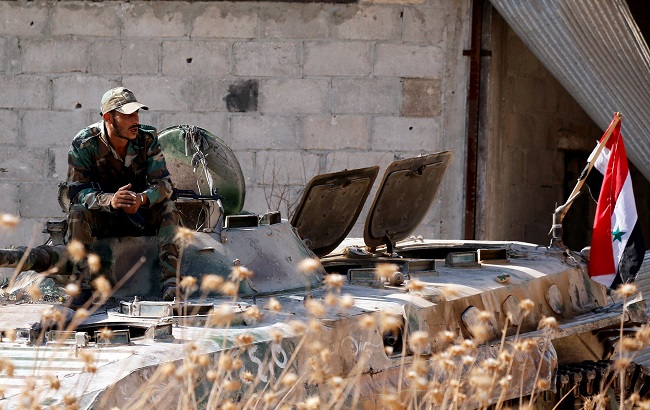 A Syrian army soldier smokes cigarette as he sits on a military vehicle in Khan Sheikhoun, Idlib, Syria August 24, 2019.