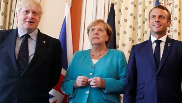 French President Emmanuel Macron, Britain's Prime Minister Boris Johnson and German Chancellor Angela Merkel pose during a meeting with G7 European members at the G7 summit in Biarritz, France, August 24, 2019. 