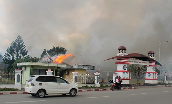 A car passes governor office building of Jayawijaya burned during a protest in Wamena, Papua, Indonesia, September 23, 2019.