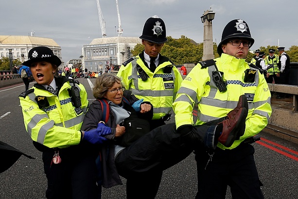 Police officers detain an activist at Lambeth Bridge during the Extinction Rebellion protest in London, Britain October 7, 2019.