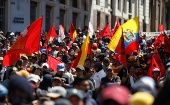 Demonstrators hold flags during a protest against Ecuador