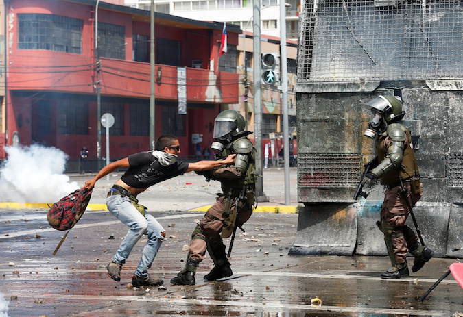 Protester and anti-riot officiers in Valparaiso, Chile October 25, 2019.