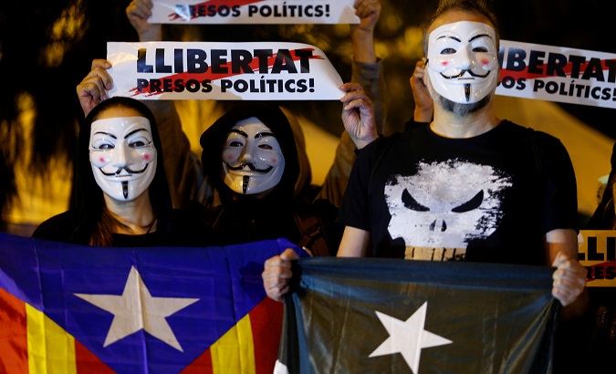 Catalan pro-independence activists hold signs reading 'Free Political Prisoners' in Barcelona, Spain, Nov. 5, 2019.