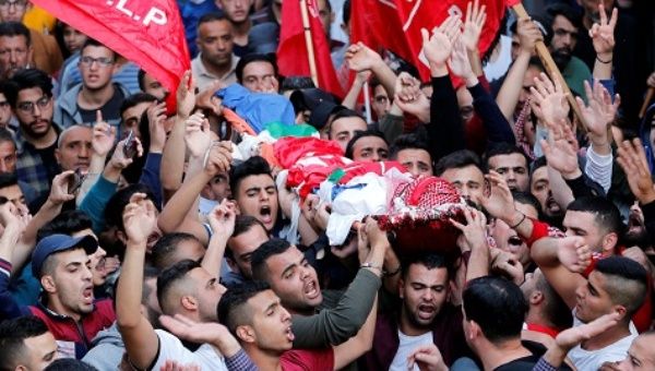 Mourners carry the body of Palestinian man Omar al-Badawi during his funeral in al-Arroub refugee camp, in the Israeli-occupied West Bank.