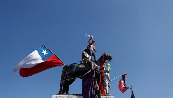 Demonstrators gesture on a statue during a protest against Chile's government in Santiago, Chile November 15, 2019. 