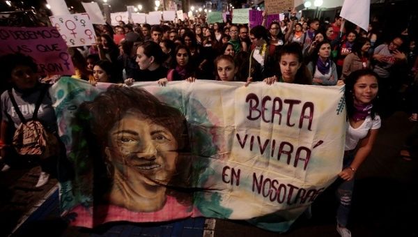Women display a banner with an image of Berta Caceres in San Jose, Costa Rica, March 8, 2019. The banner reads, 'Berta will live in us.'
