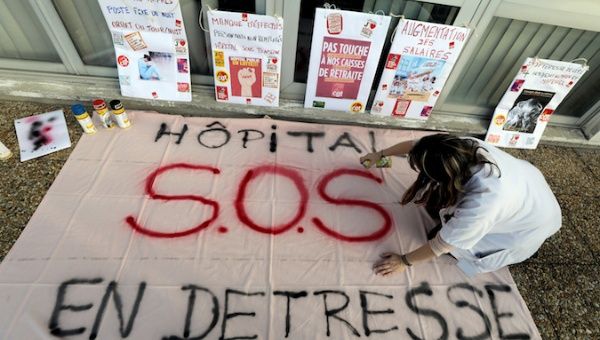 A hospital staff prepares a banner that reads 
