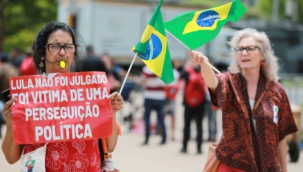 Woman holds a sign that reads 'Lula was not tried. He's the victim of political persecution' in Porto Alegre, Brazil, Nov. 27, 2019.