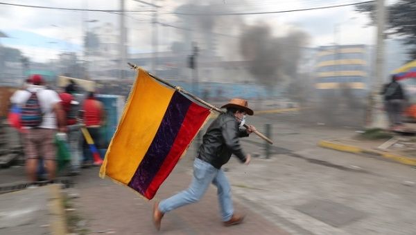 A demonstrator runs while holding an Ecuadorian flag during a protest against Ecuador's President Lenin Moreno's austerity measures in Quito, Ecuador October 12, 2019. Picture taken October 12, 2019.