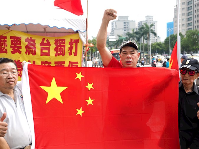 Members of a pro-China group display China's national flag in Taipei, Taiwan