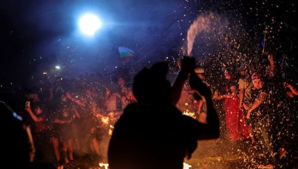 Demonstrators react around a bonfire as they ring in the new year at Plaza Italia during a protest against Chile's government in Santiago, Chile January 1, 2020.
