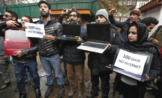 FILE PHOTO: Kashmiri journalists display laptops and placards during a protest demanding restoration of internet service, in Srinagar, November 12, 2019.