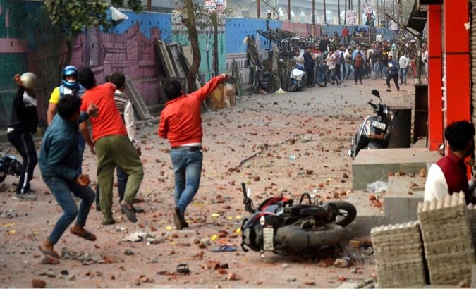 People supporting a new citizenship law and those opposing the law, throw stones at each other during a clash in Maujpur area of New Delhi, India, Feb. 23, 2020.