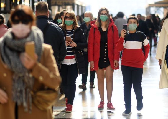People wear masks as they walk in Milan, Italy, Feb. 24, 2020.