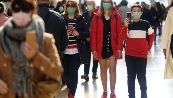People wear masks as they walk in Milan, Italy, Feb. 24, 2020.