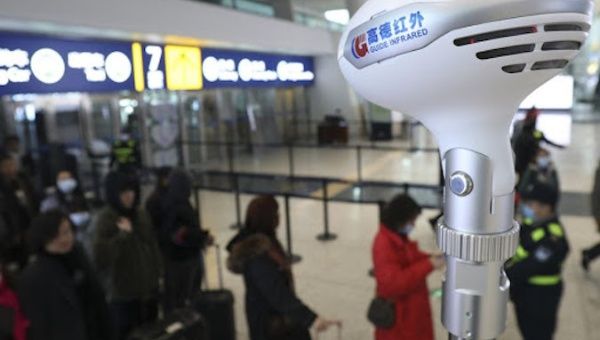 Staff members take passengers' body temperature at Tianhe International Airport in Wuhan, capital of central China's Hubei Province, Jan. 21, 2020.