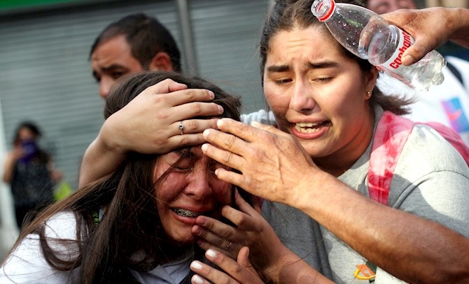 Woman hit by pepper spray thrown by Military Police, Santiago, Chile, March 11, 2020.