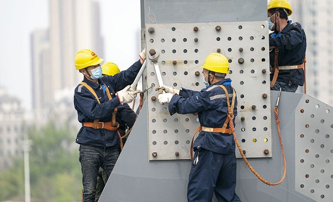 Workers work at the construction site of the Jianghan Bridge in Wuhan, China, March 24, 2020.
