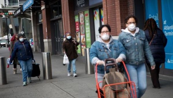 Pedestrians wearing face masks are seen in a street in the Brooklyn borough of New York, the United States, on April 3, 2020.