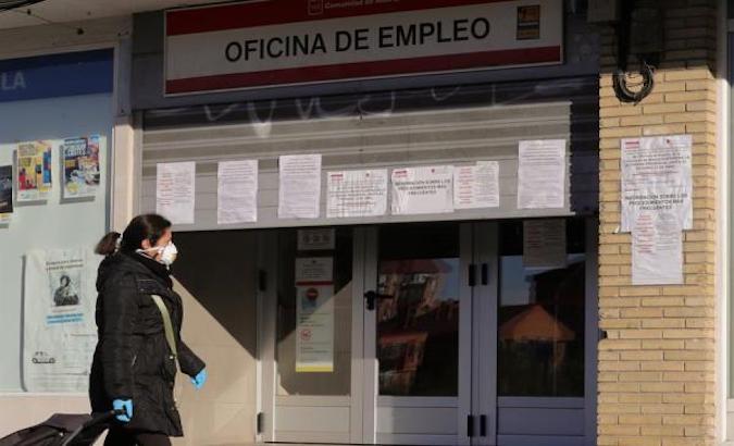 A woman walks past an employment office in Madrid, Spain, April 28, 2020.
