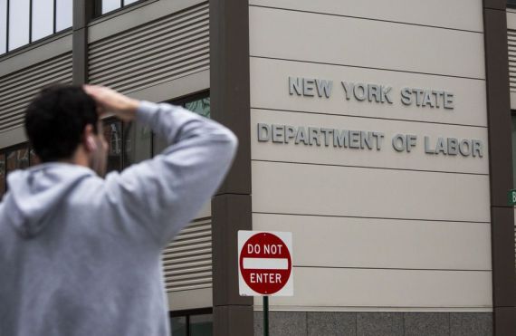 A pedestrian stands in front of the New York State Department of Labor office in the Brooklyn borough of New York, the United States, on May 8, 2020.