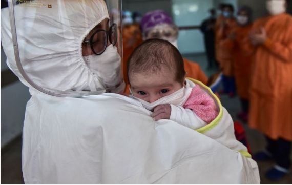 A medical worker holds a baby at the Okmeydani Prof. Cemil Tascioglu Hospital in Istanbul, Turkey, on May 12, 2020.