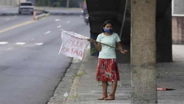 A girl asks for food aid with a white flag, San Salvador, El Salvador, May 17, 2020.