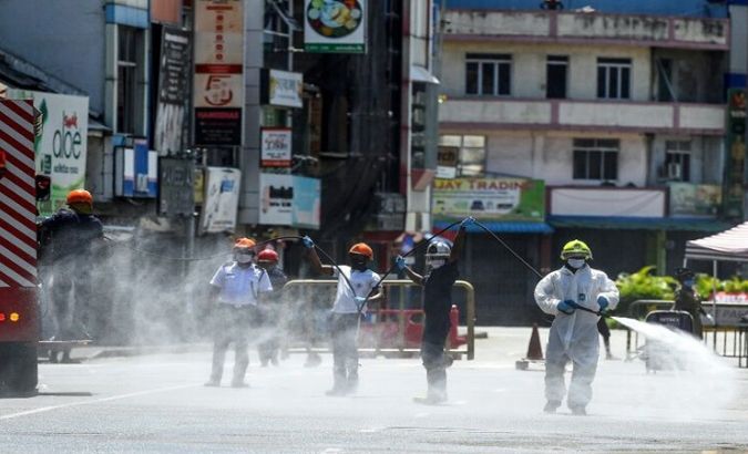 Firefighters spray disinfectant to sanitize a road as a preventive measure against the coronavirus in Colombo, Sri Lanka on May 10, 2020