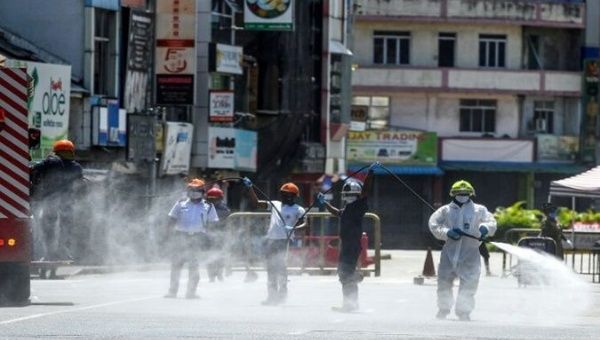 Firefighters spray disinfectant to sanitize a road as a preventive measure against the coronavirus in Colombo, Sri Lanka on May 10, 2020 