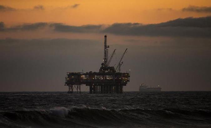An oil rig sits off the shore at sunset in Huntington Beach, California, May  11, 2020.