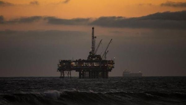 An oil rig sits off the shore at sunset in Huntington Beach, California, May  11, 2020.