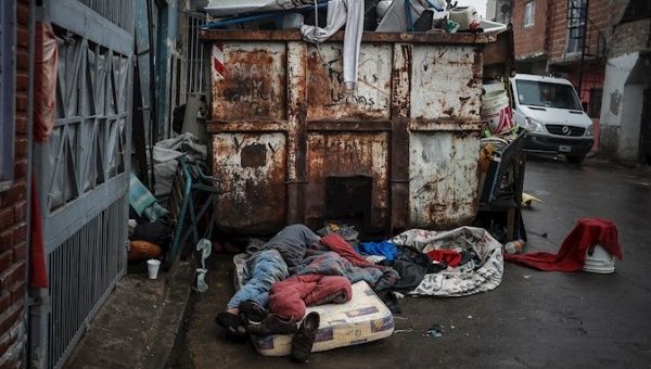 A homeless man sleeps next to a garbage container, Ricciardelli neighborhood, Buenos Aires, Argentina, June 5, 2020.