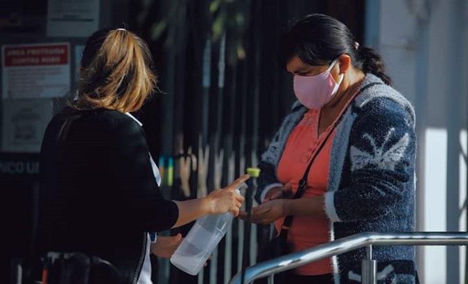 Women share hand sanitizer. Santa Cruz, Bolivia. June 15, 2020.