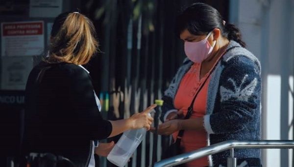 Women share hand sanitizer. Santa Cruz, Bolivia. June 15, 2020.
