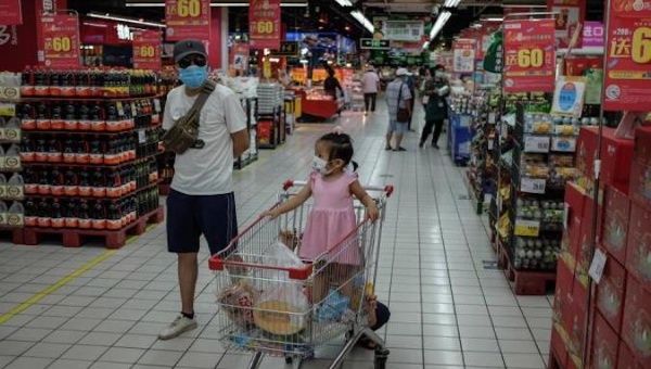 People wearing face masks shop in a supermarket in Beijing, China, June 16, 2020.